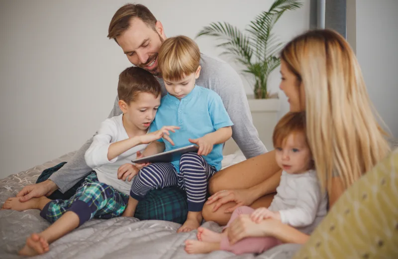 Familia con varios niños viendo una tableta